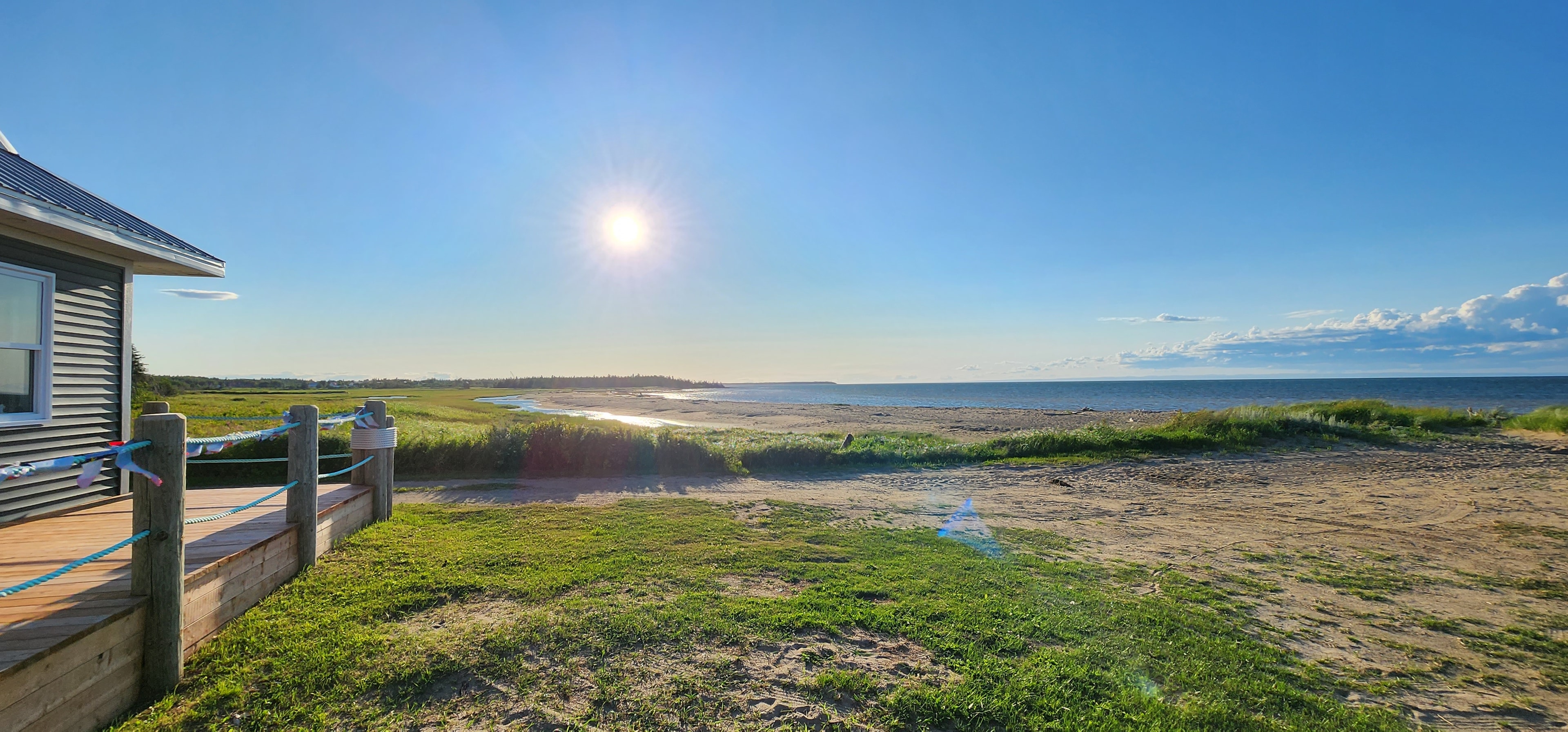 Vue sur le bord de mer avec soleil et maison